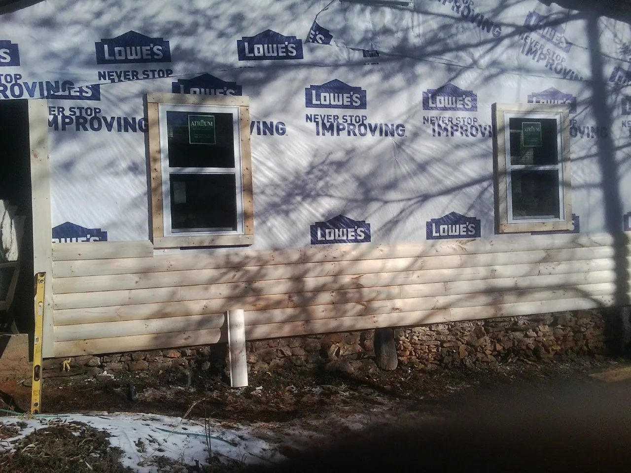 House wrap and new log siding going up on an exterior wall in Crater Lake