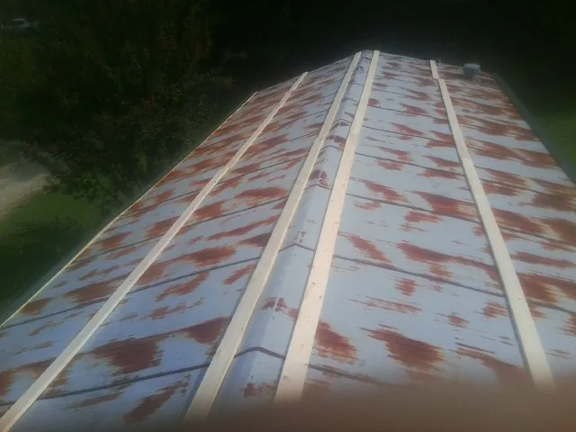 Rusted metal roof panels with new wood purlins before replacement — Storm Damage Roof Repair in Crater Lake by Roofing Brothers