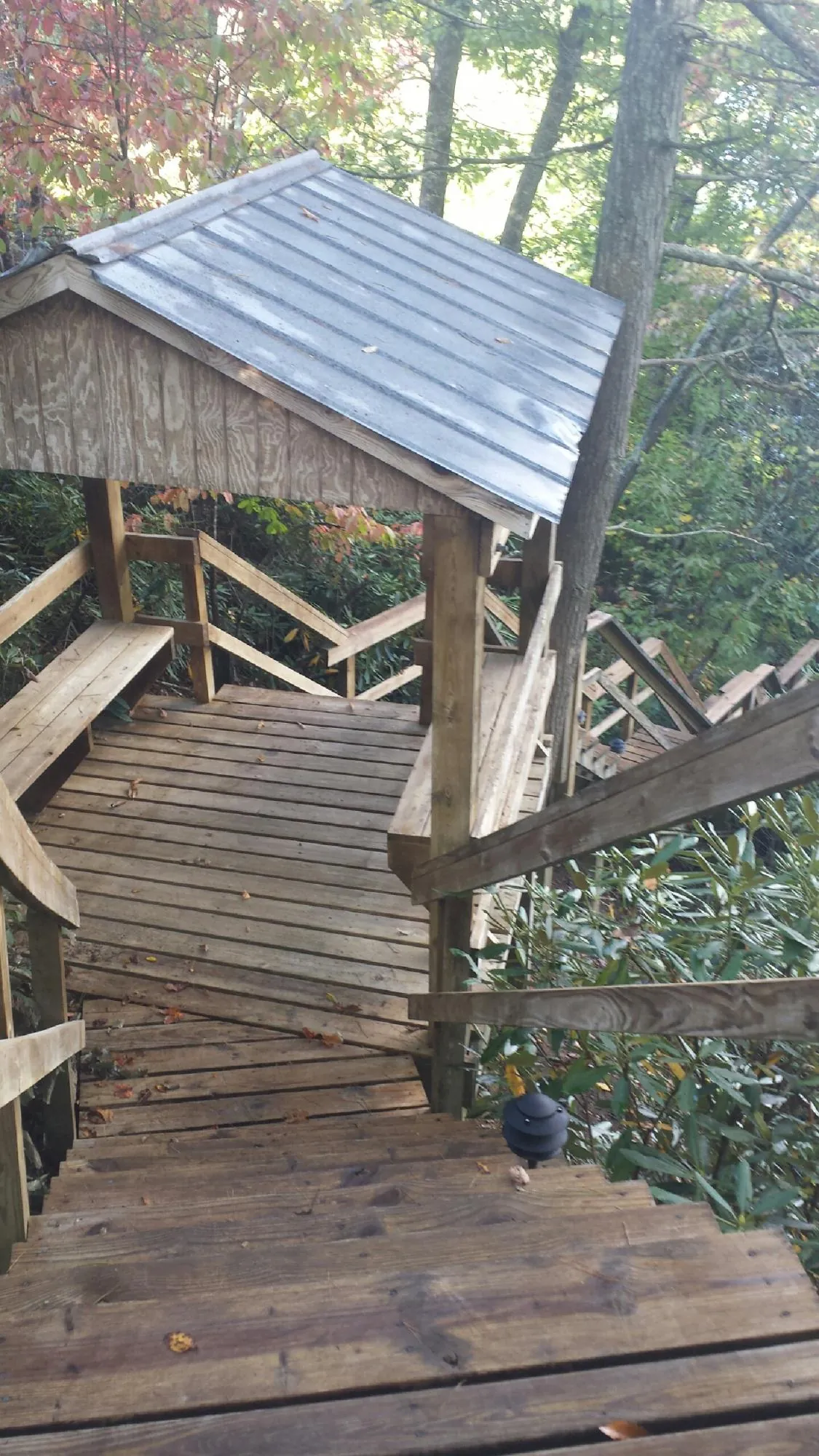 Metal roofed shelter over wooden steps on a wooded walkway — Skylight Repair & Installation work by our crew in Crater Lake