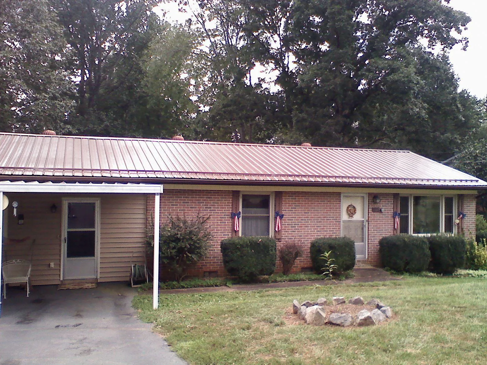 Bronze metal roof and carport on a brick ranch home — Roof Repair work by our crew in Crater Lake